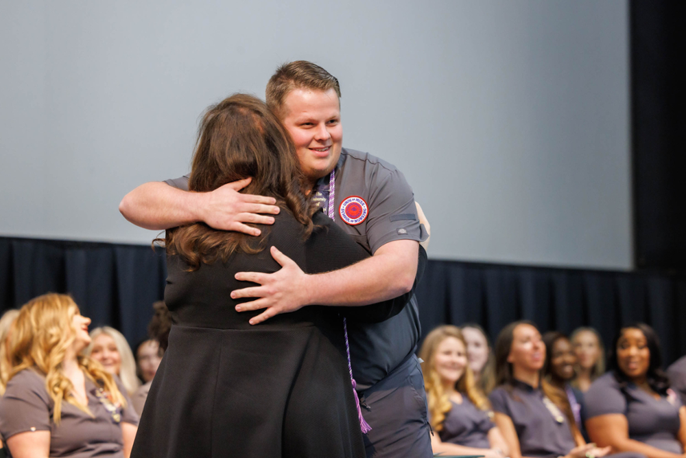 Noah Sasser getting pinned by dean during Pinning Ceremony.
